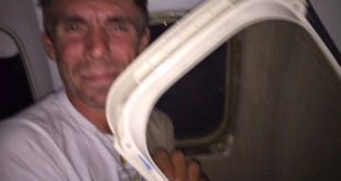 Gibson cầm tấm cửa máy bay đã rơi xuống đùi anh