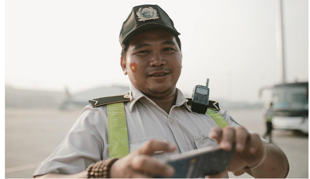 Một nhân viên mặt đất cũng dán logo hình cờ Tổ Quốc trên má để cổ vũ cho đội tuyển Việt Nam