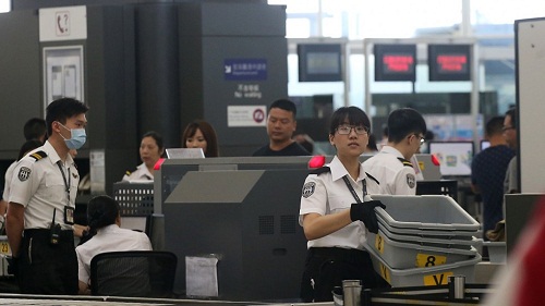 Nhân viên an ninh tại khu vực kiểm tra của sân bay quốc tế Hong Kong. 
